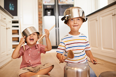 kids playing on kitchen floor with pots and pans